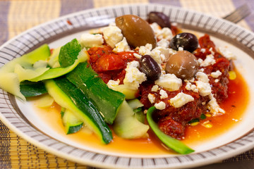 Vegetarian dinner with squash, garlic, olives, feta cheese and  crushed tomatoes.