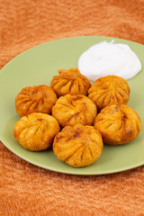 Fried Momos is a Traditional Dumpling Food From Nepal Served with Schezwan Sauce & Cream