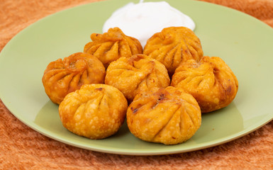 Fried Momos is a Traditional Dumpling Food From Nepal Served with Schezwan Sauce & Cream