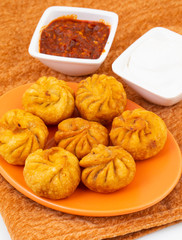 Fried Momos is a Traditional Dumpling Food From Nepal Served with Schezwan Sauce & Cream
