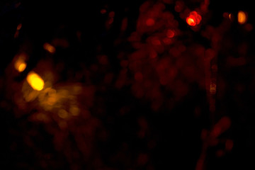 Fototapeta na wymiar Yellow glitter lights on a black background. Bokeh of holiday lights on a black background. Background abstract yellow glitter lights. Gold abstract bokeh background on black. Defocus.