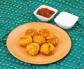 Fried Momos is a Traditional Dumpling Food From Nepal Served with Schezwan Sauce & Cream