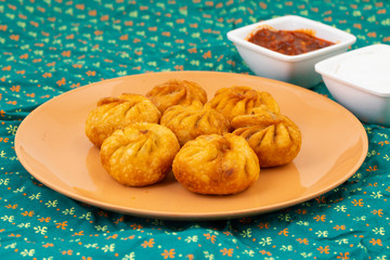 Fried Momos is a Traditional Dumpling Food From Nepal Served with Schezwan Sauce & Cream