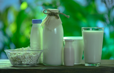 dairy products stand on a wooden table against the background of nature