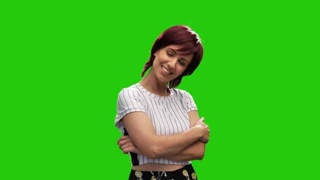Cheerful short haired brunette woman crossing hands and posing in green screen