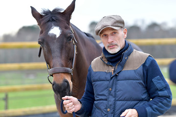 Obraz premium Portrait of horseman standing by horse