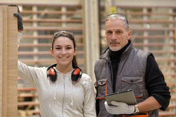 Portrait of young apprentice with trainer in workshop