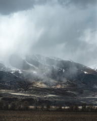 gray gloomy mountains under a storm of snow and rain