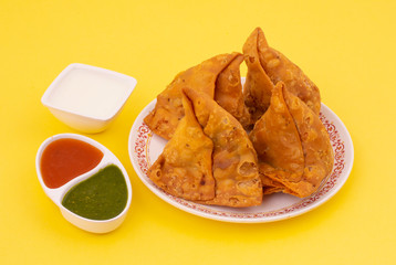Indian Street Food Samosa or Samosas is a Crispy And Spicy Triangle Shape Snack Which Has Crisp Outer Layer of Maida & Filling of Mashed Potato, Peas And Spices. Served With Chutney, Ketchup or Curd