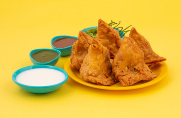 Indian Street Food Samosa or Samosas is a Crispy And Spicy Triangle Shape Snack Which Has Crisp Outer Layer of Maida & Filling of Mashed Potato, Peas And Spices. Served With Chutney, Ketchup or Curd