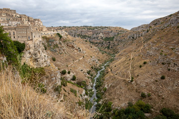 View of Gravina river canyon and park of the Rupestrian Churches of Matera with houses in caves di Murgia Timone near ancient town Matera (Sassi), , Basilicata,  Italy