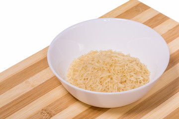 Rice grains in a white bowl on the table.