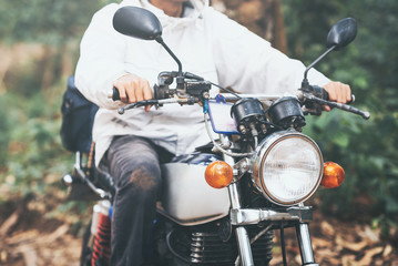 Hipster Asian biker gun hand hold throttle control of classic motorcycle style travel. Brutal urban...