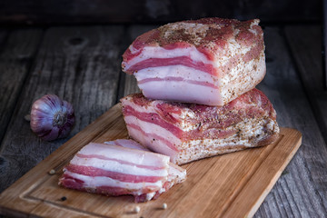Chunks of salted bacon on dark background.