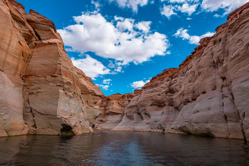 Fototapeta na wymiar View of narrow, cliff-lined canyon from a boat in Glen Canyon National Recreation Area, Lake Powell, Arizona.
