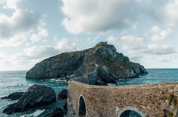 Scenic view of famous island in the basque country against cloudy sky