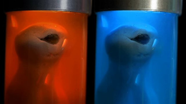 Aliens in cylindrical glass vessels (flasks), in a liquid with air supply (bubbles), similar to a laboratory for experiments, similar to mutants, close-up