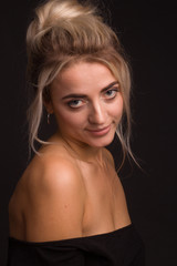 Fototapeta premium Studio portrait of a young beautiful girl on a black background