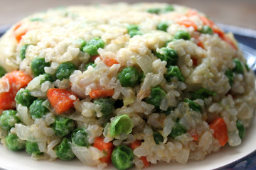 Fried rice with vegetables on blue plate close up view. Asian cuisine concept
