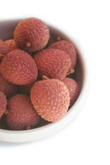 Fresh ripe litchi or lychee fruits in a bowl isolated on white background. Litchi chinensis fruit