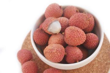 Fresh ripe litchi or lychee fruits in a bowl isolated on white background. Litchi chinensis fruit