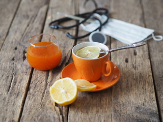 Sea buckthorn jam, tea, lemon for the treatment of influenza. Warm clothes, a thermometer, a medical tool and an appicator. Sprig of dry sea buckthorn on a wooden ancient background.