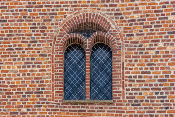 Red brick wall with vaulted dual window