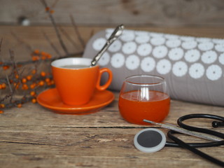 Sea buckthorn jam, tea, lemon for the treatment of influenza. Warm clothes, a thermometer, a medical tool and an appicator. Sprig of dry sea buckthorn on a wooden ancient background.