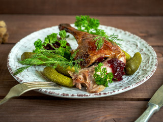 Hot lunch of baked duck leg with fresh herbs and pickles