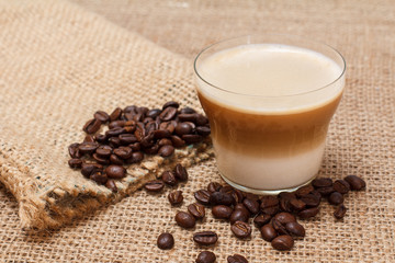 Coffee cappuccino and coffee beans on sackcloth background