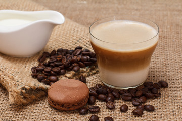 Coffee cappuccino, cream and coffee beans on sackcloth background