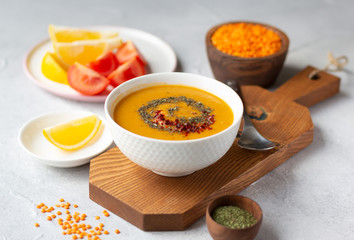 A bowl of thick red lentil soup served with lemon, dried mint and paprika. Turkish and Indian cuisine
