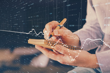 Double exposure hands with stock market chart.