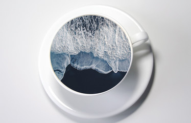 White cup with water. Sea. Ocean. Sea waves. Creative postcard. Sea in the hand.