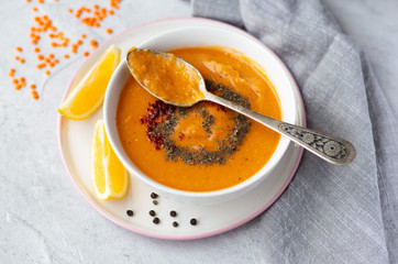 Thick red lentil soup served with lemon, dried mint and paprika. Turkish and Indian cuisine. Top view