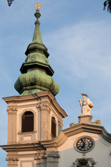 Tower of Stiftskirche Church on Mariahilfer Strasse Street in Vienna in Austria. Cathedral archtecture in Wien. Basilica Building landmark. Blue sky background