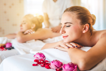 Obraz na płótnie Canvas Beautiful young attractive Caucasian woman having body massage by Thai Masseur in spa salon. Beauty treatment and body care concept.