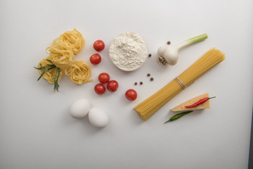 Fototapeta na wymiar Ingredients for pasta cooking on white background