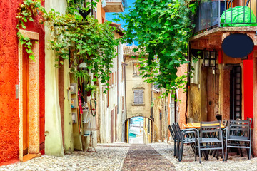 Small town narrow street view with colorful houses in Malcesine, Italy during sunny day. Beautiful lake Garda.