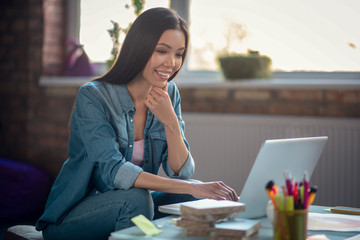 Positive Asian woman working on her project
