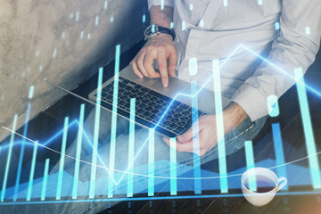 Forex graph with businessman working on computer in office on background. Concept of analysis. Double exposure.