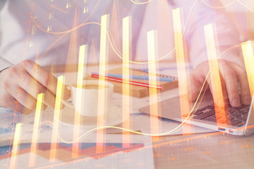 Forex graph with businessman working on computer in office on background. Concept of hardworking. Double exposure.