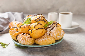 Profiteroles or gougeres (choux à la crème) - French choux pastry balls filled with custard or cottage cheese sprinkled with powdered sugar