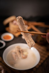 A cook is preparing a Bak kut teh for service to his customer in a Chinese restaurant.