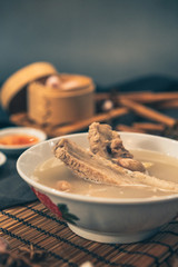 A cook is preparing a Bak kut teh for service to his customer in a Chinese restaurant.