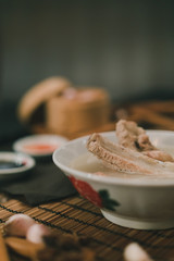 A cook is preparing a Bak kut teh for service to his customer in a Chinese restaurant.