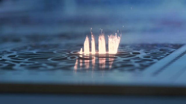 Industrial Laser cutting on wood, cutting a pattern on a plywood sheet and moving slowly, close up. A large technological machine burns through a wooden board. New technologies in woodworking.