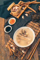 A cook is preparing a Bak kut teh for service to his customer in a Chinese restaurant.