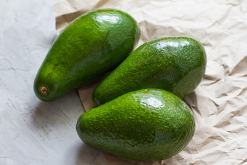 three whole avocados. avocado fruit on a gray background. healthy fruits and vegetables. healthy food. the view from the top. ingredients for making salad. space for text. the concept of diet 