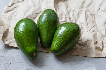 three whole avocados. avocado fruit on a gray background. healthy fruits and vegetables. healthy food. the view from the top. ingredients for making salad. space for text. the concept of diet 